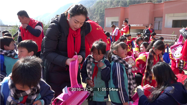 富創(chuàng)工業(yè)自動化梁宗富等愛心企業(yè)家?guī)椭∨笥寻咽盏降膼坌奈镔Y放進書包內(nèi)